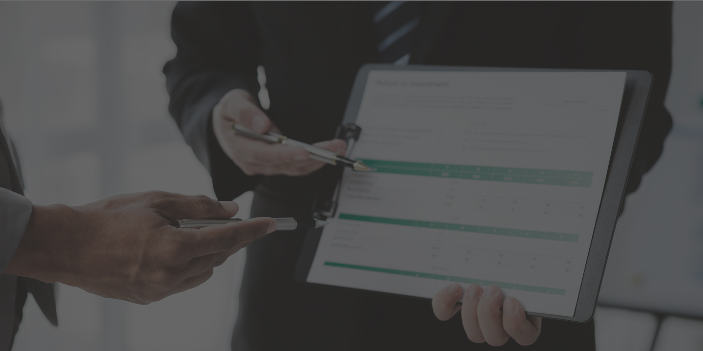men with pens pointing to clipboard